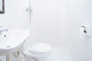 A bathroom with a toilet, sink, and shower. - C Star Travellers Inn Redpartner (Oslob)