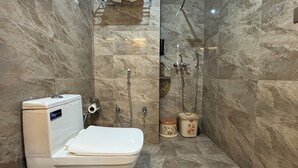 A bathroom with a toilet, a shower, and a sink. - Hotel Down Town (Jaipur)