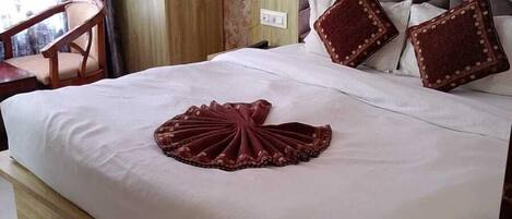 A neatly made bed with a decorative pillow and a wooden headboard.