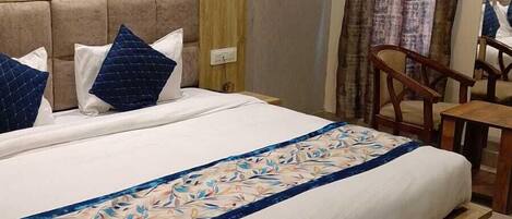 A neatly made bed with a floral bedspread, a wooden headboard, and two pillows.