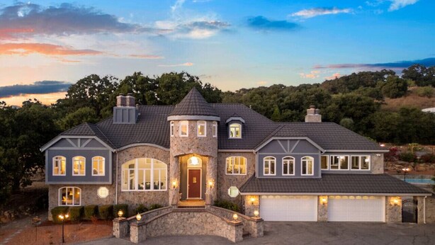 A large, two-story house with a stone facade, multiple windows, and a garage. - Grand Villa Castle in San Jose (San Jose)