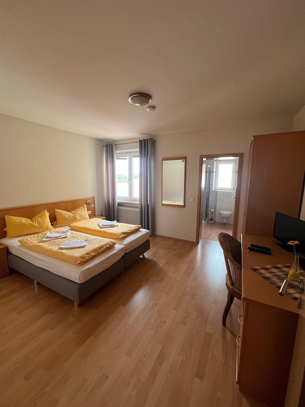Una habitación de hotel con una cama grande, un escritorio con ordenador y vistas al exterior.
