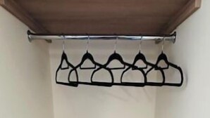 Ein Zimmer mit Holzregal und Garderobe.