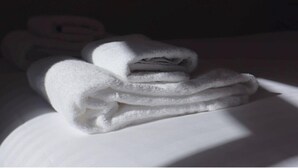 Ein Stapel weißer Handtücher auf einem Bett.