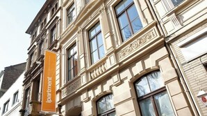 En flervåningsbyggnad med en framträdande orange skylt där det står ”lägenheter”.