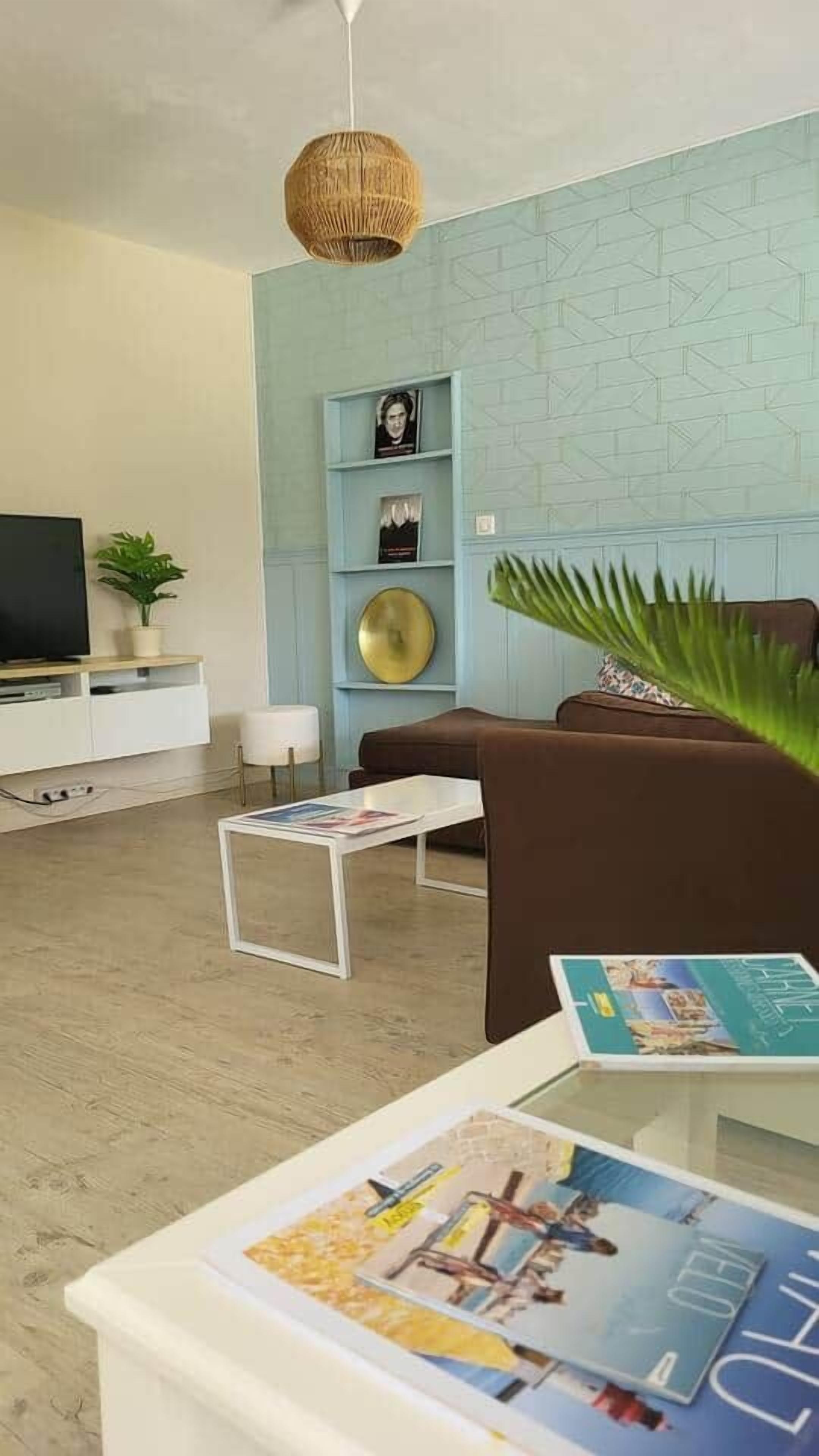 A modern living room with a sofa, coffee table, and a TV on a stand.