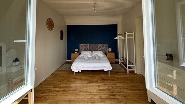 A bedroom with a bed, bedside tables, a wardrobe, and a window.