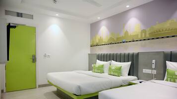 A hotel room with two beds, a green door, and a cityscape mural on the wall.