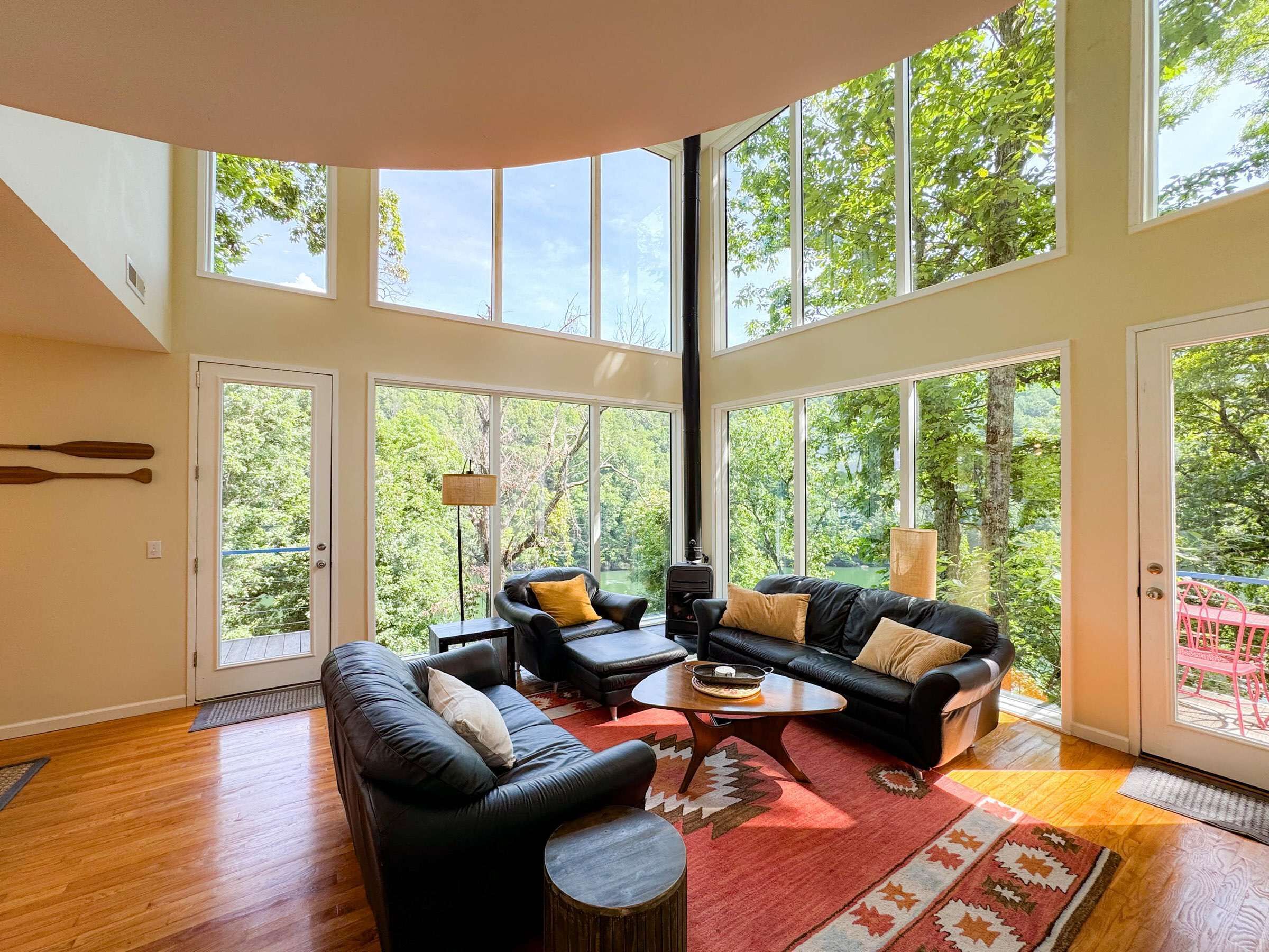 A spacious living room with a large window, a fireplace, and a view of the outdoors.