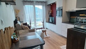 Eine moderne Küche mit Essbereich, Holzboden und Blick ins Freie.
