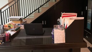 Un escritorio con una computadora portátil, papeles desparramados y un calendario.