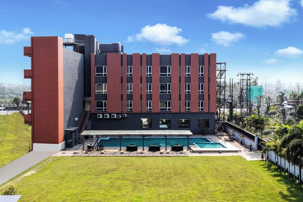 A modern building with a swimming pool and outdoor seating area.