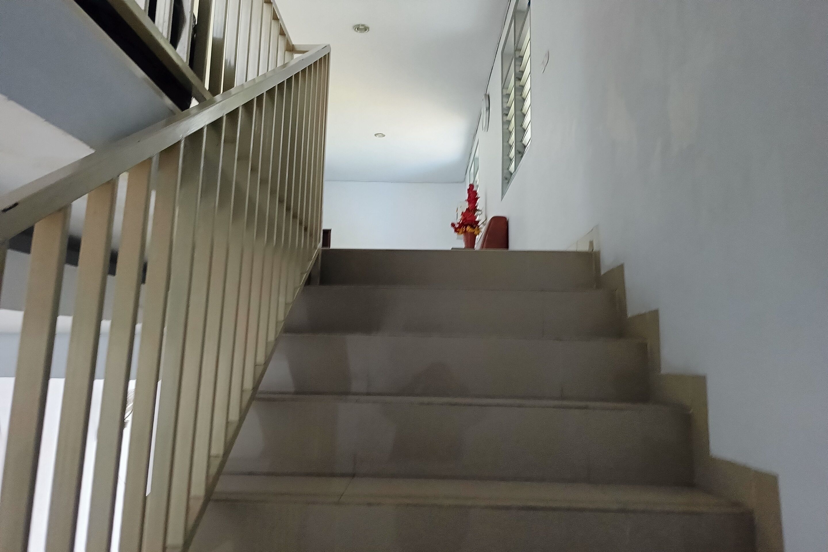 Un escalier doté d’une rampe et d’un luminaire fixé au mur.