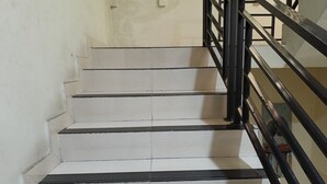 Un escalier avec des marches blanches et des rampes noires.