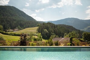 Piscina con vistas a un paisaje montañoso y una cerca de madera.