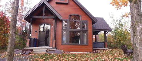A two-story house with a prominent gable roof, a front porch, and a covered porch area.