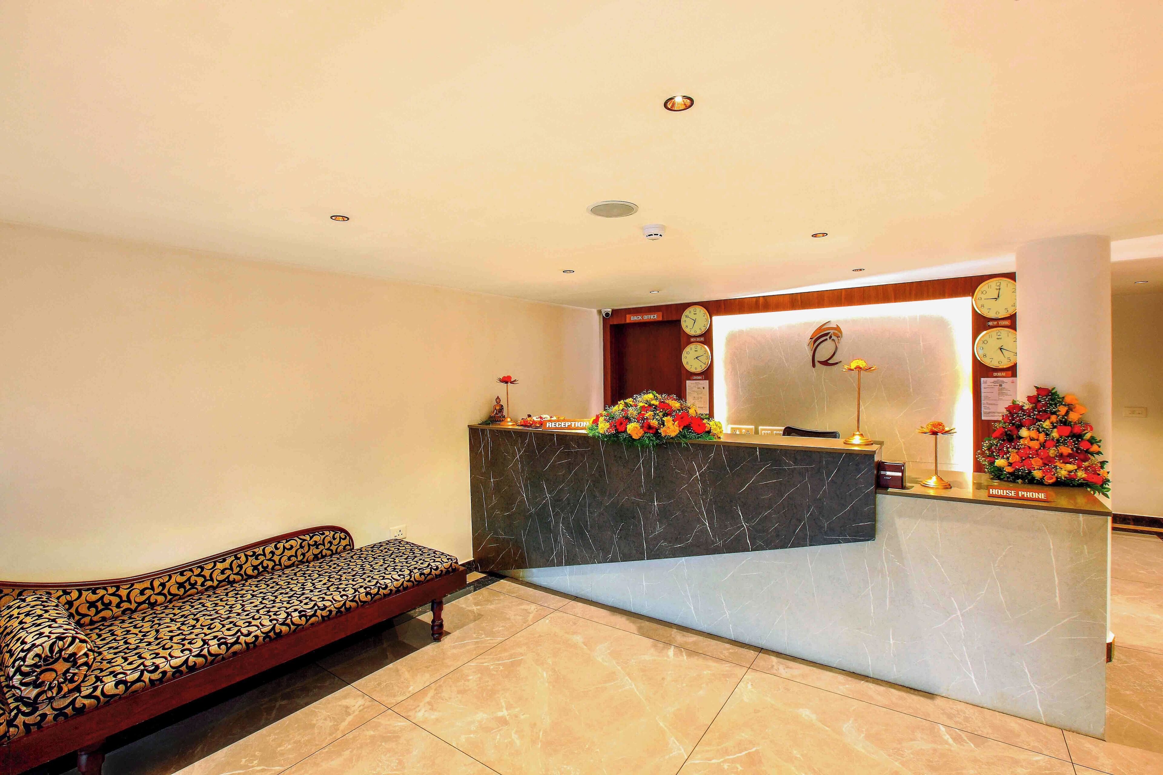 A reception area with a sofa, a reception desk, and a wall clock.