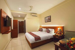 Relax in comfort with a large bed, flat-screen TV, and ceiling fan.