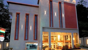 Un bâtiment moderne doté de grandes fenêtres et d’un toit plat, avec un hall d’entrée bien éclairé et un espace bar bien visible.