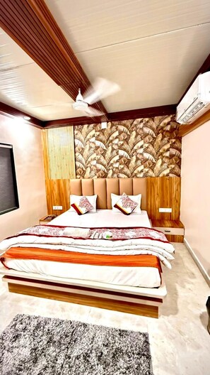 A modern bedroom with a large bed, a ceiling fan, and a patterned wall.