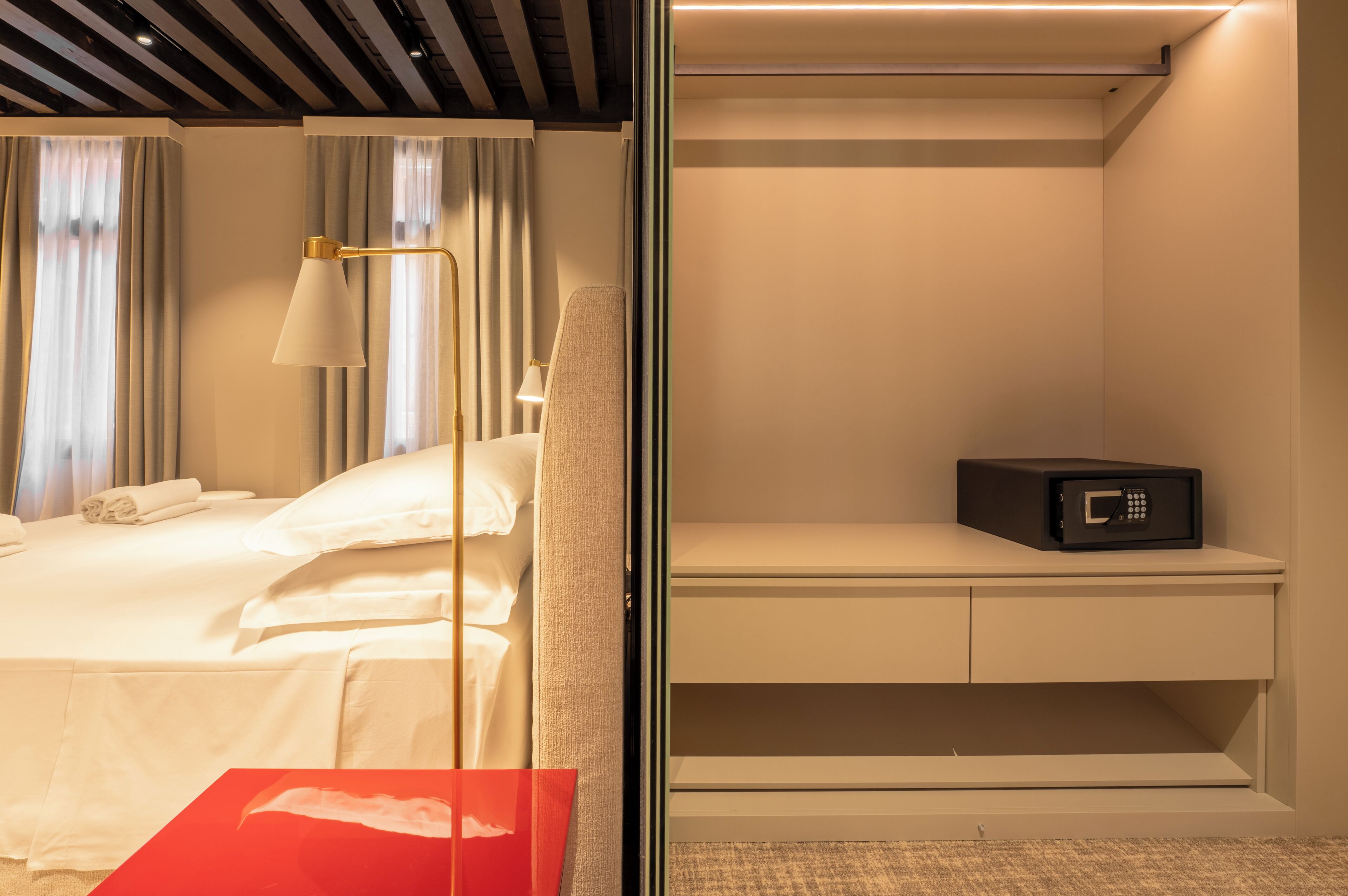 Une chambre d’hôtel équipée d’un lit, d’une table de chevet, d’une lampe et d’un four à micro-ondes.