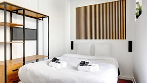 Una habitación de hotel con una cama, una estantería de madera y un panel vertical de madera en la pared.