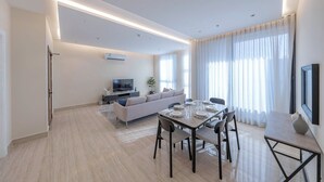 A modern living room with a sofa, TV, and dining area. - Mabaat - Al Qirawan - 557 (Riyadh)