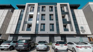 A modern building with a parking lot containing several cars. - Mabaat - Al Qirawan - 557 (Riyadh)