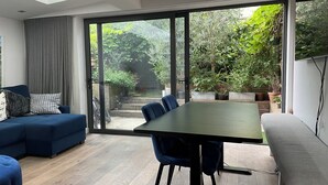 Ein modernes Wohnzimmer mit einem großen Schiebeglasfenster zum Garten.