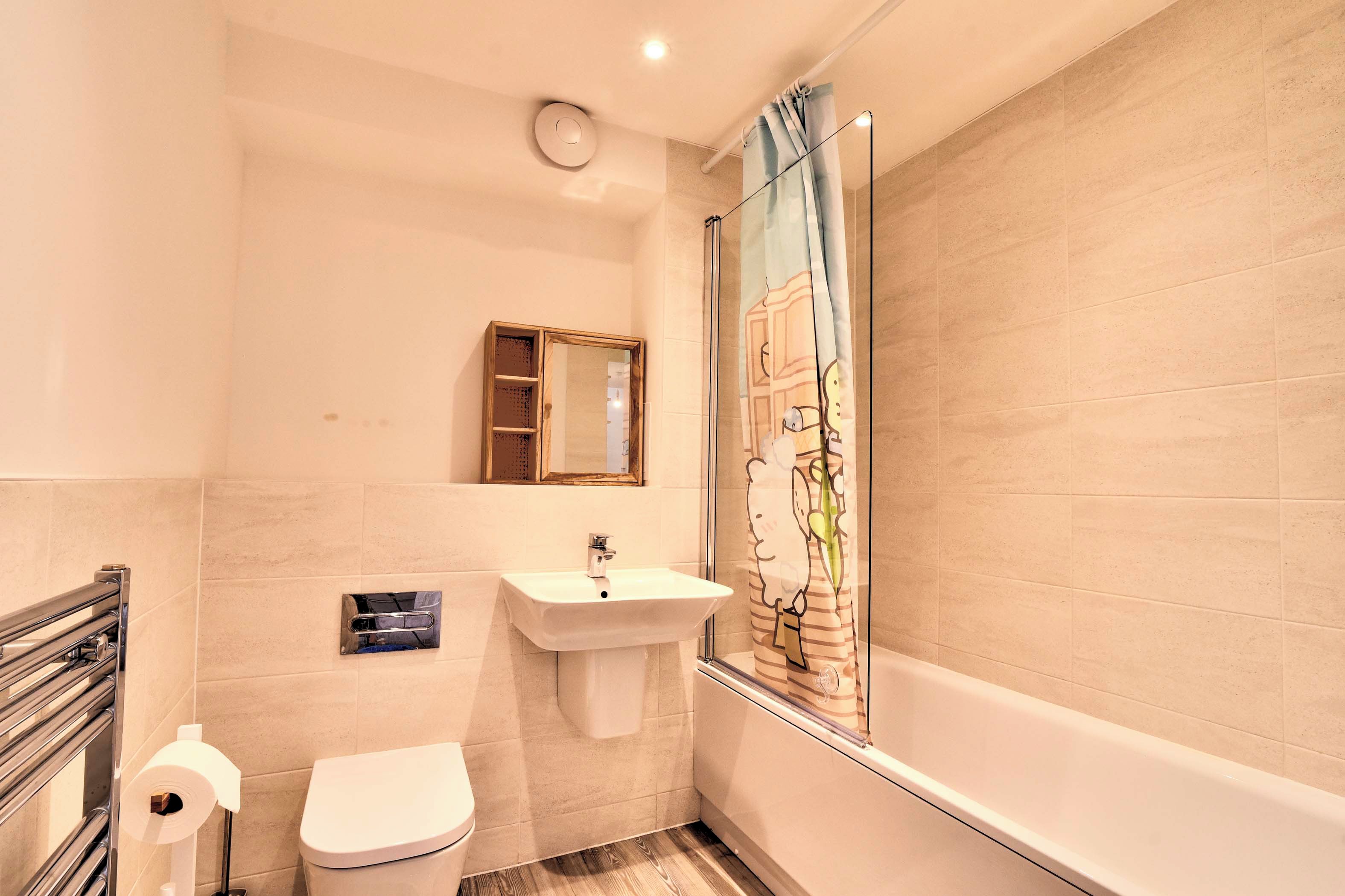 A bathroom with a toilet, sink, and shower area.