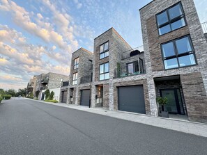 Un edificio residenziale moderno a più piani, con facciate in mattoni, ampie finestre e tetto piatto.