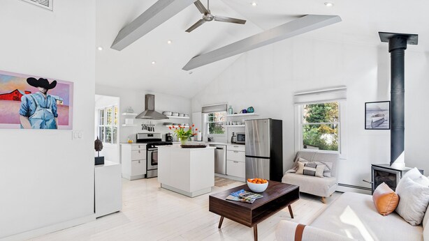 A spacious living area with a sofa, coffee table, and a fireplace. - Charming 2-bedroom cottage in Sag Harbor with AC, WiFi (Sag Harbor)