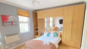Une chambre à coucher avec un lit, une armoire en bois et un radiateur.