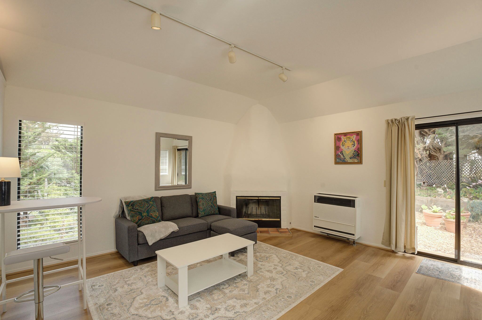 Un salon moderne comprenant un canapé, une table basse, une cheminée et une grande porte-fenêtre coulissante donnant sur l’extérieur.