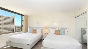 A hotel room with two beds, a large window, and a city view.