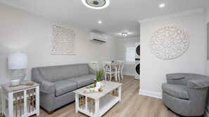 A modern living room with a grey sofa, a coffee table, and a round decorative wall piece.