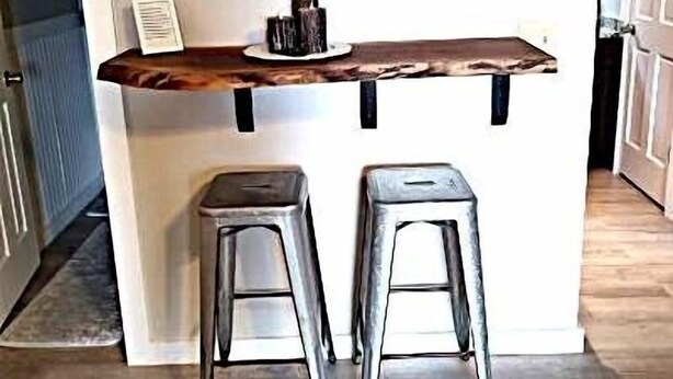A kitchen area with a wooden shelf above two metal stools, a framed painting, and a small table with a candle. - 4105  Slopes & Spokes Perfect Location (Beech Mountain)
