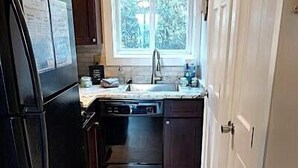 A narrow kitchen with a refrigerator, dishwasher, and a window above the sink. - 4105  Slopes & Spokes Perfect Location (Beech Mountain)