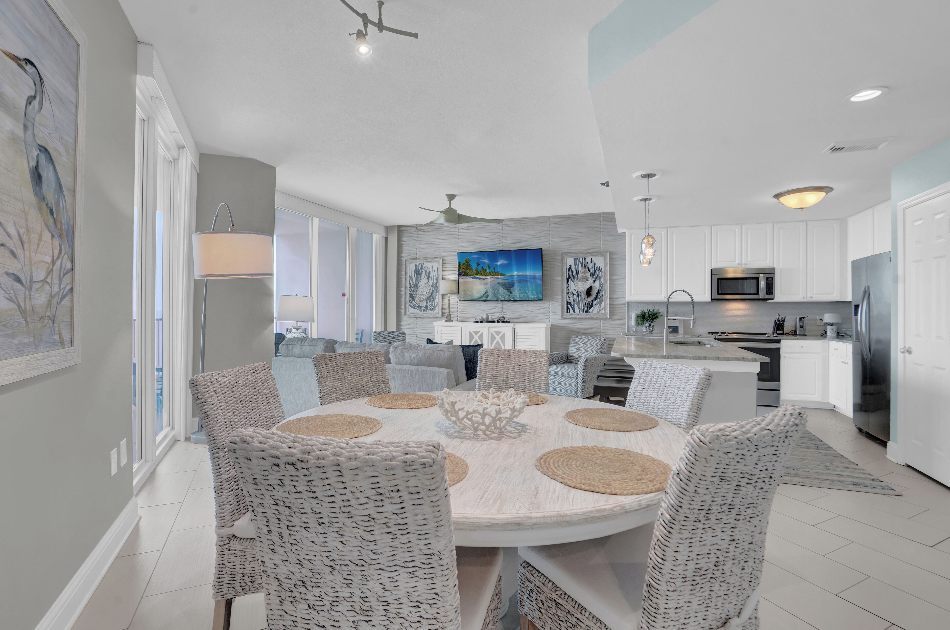 A modern kitchen with white cabinets, a stainless steel refrigerator, and a microwave.
