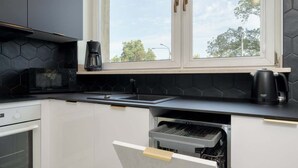 Une cuisine équipée d’un four à micro-ondes, d’une machine à café et d’un lave-vaisselle.