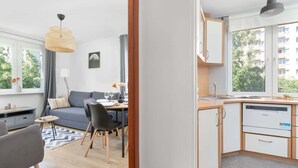 Un appartement moderne comprenant une cuisine, un coin repas et un salon.