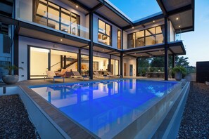 A modern two-story house with a swimming pool, large windows, and a staircase leading to the upper floor. - Loft-Style 4BR Salt Pool Villa Sunset 6 (Rawai)