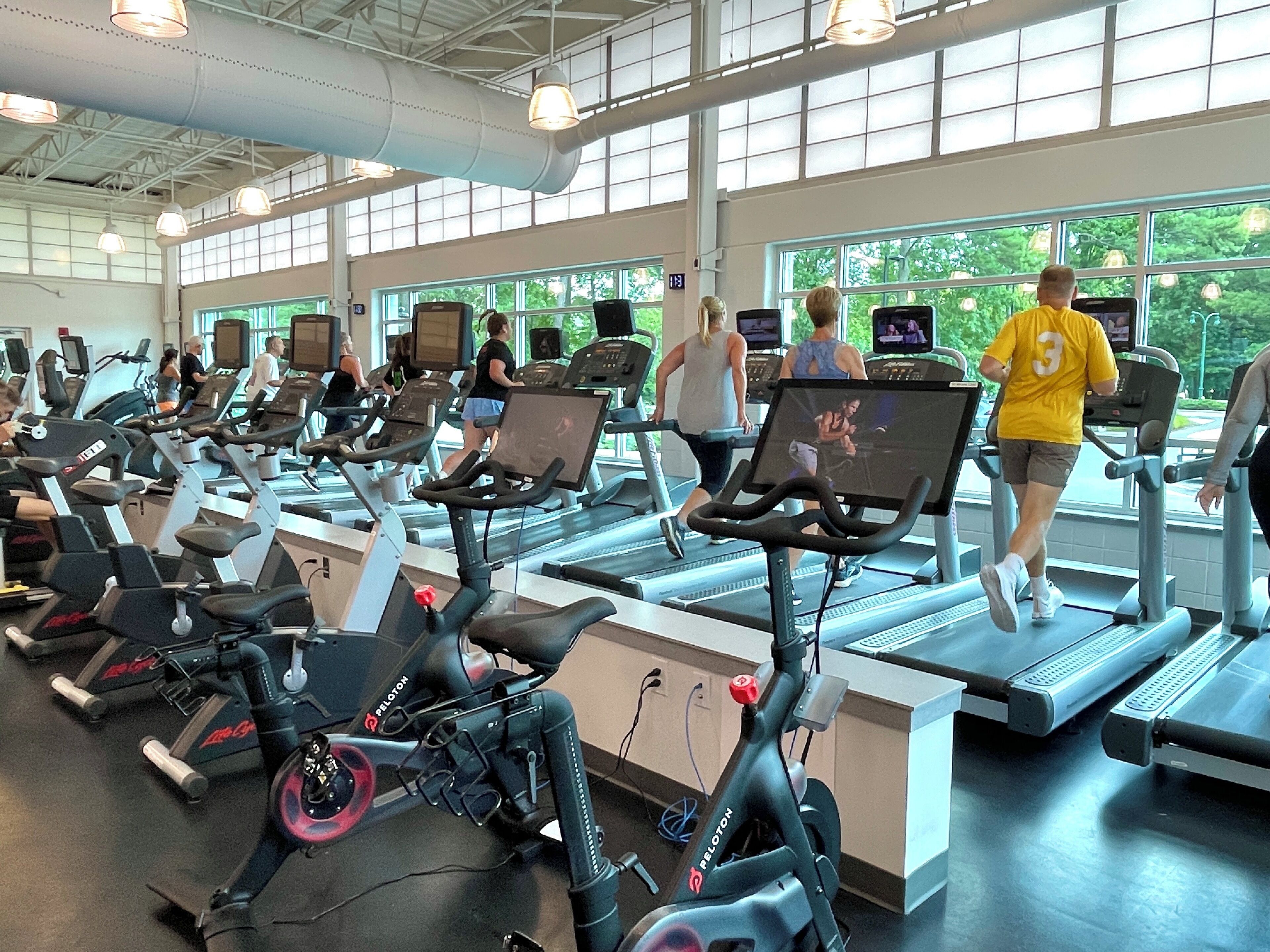 Een sportschool met loopbanden, hometrainers en elliptische trainers.