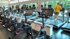 A gym with treadmills, stationary bikes, and elliptical machines.