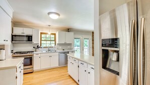 A modern kitchen with white cabinets, stainless steel appliances, and a wooden floor. - West Union Home w/ Saltwater Pool on 2 Acres! (West Union)