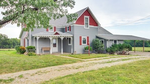 A two-story house with a porch, a covered area, and a large lawn. - Erie Farmhouse w/ Fire Pit + Grill: Pets Welcome! (Erie)
