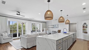 A spacious kitchen with a large island, grey cabinets, and a modern pendant light fixture. - Rooftop Comm Pool - WaterHouse 204 by Royal Destinations (Inlet Beach)