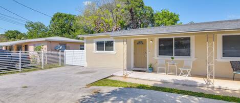 A single-story house with a front porch, a small patio, and a fenced backyard.