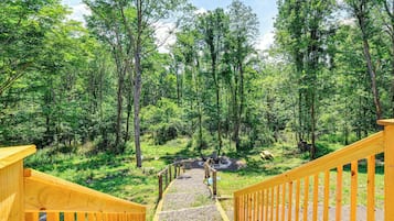 Una escalera de madera que conduce a una zona boscosa con una mesa y sillas de picnic.