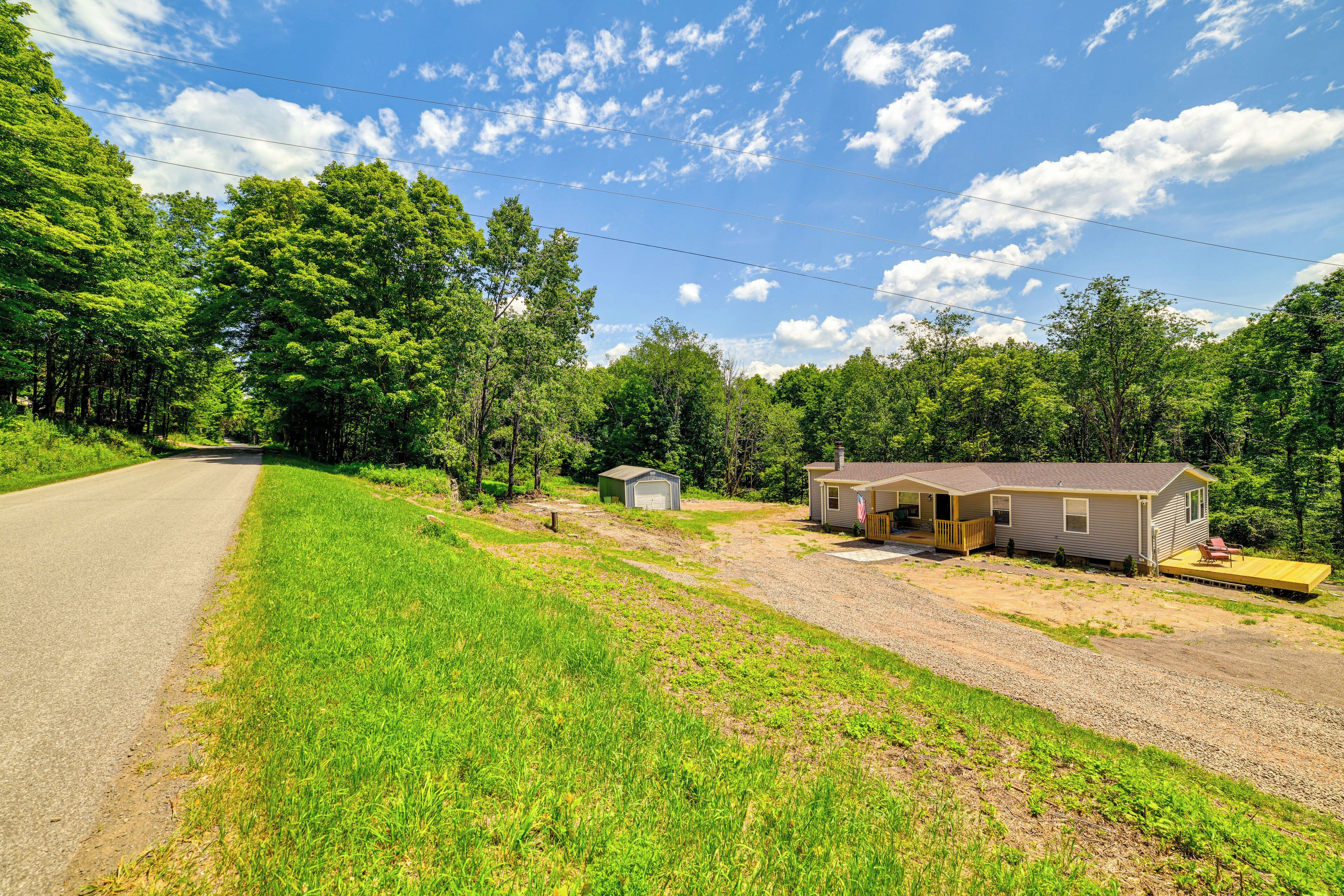 A rural road with a house and a small shed.